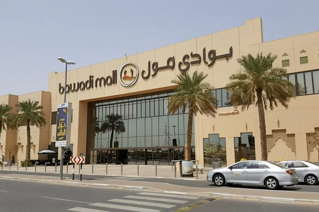 Bawadi Mall entrance with palm trees and taxis.