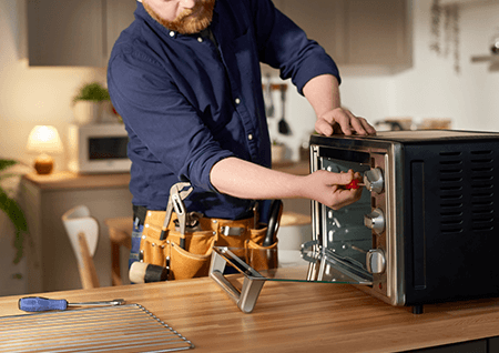 Man repairing a toaster oven.