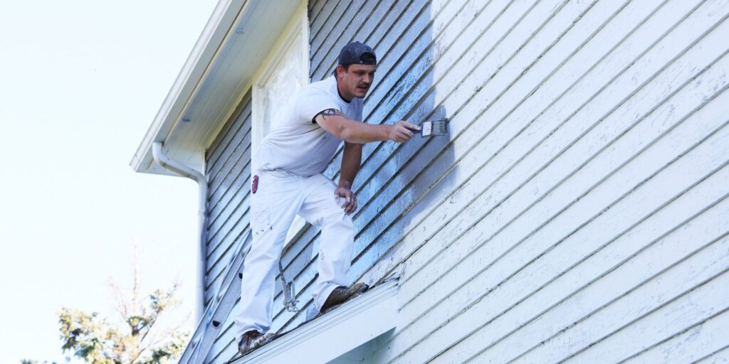 Man painting house exterior.