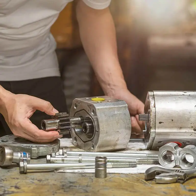 Close-up of hands assembling metal machine components.