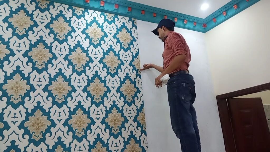 Man applying new patterned wallpaper.