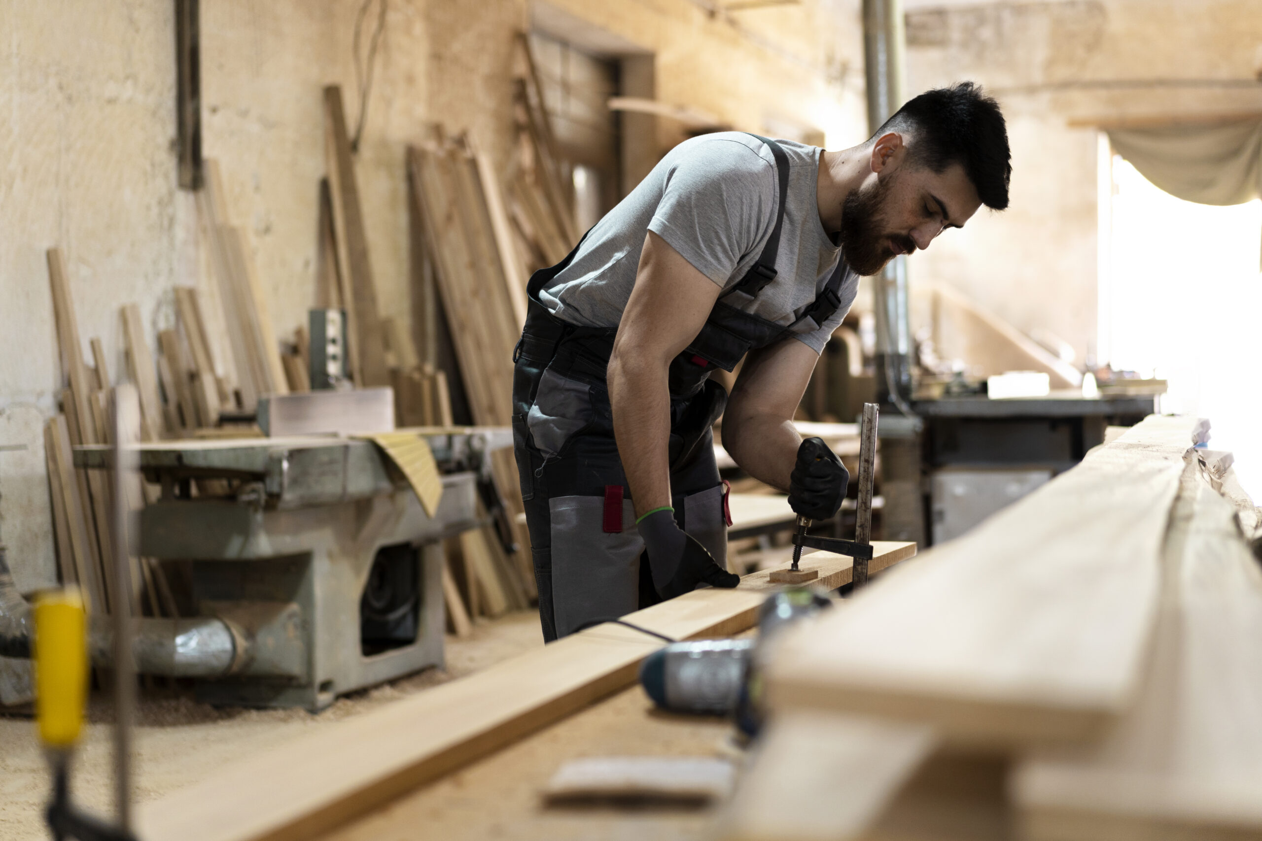 Carpenter shaping wood in workshop.