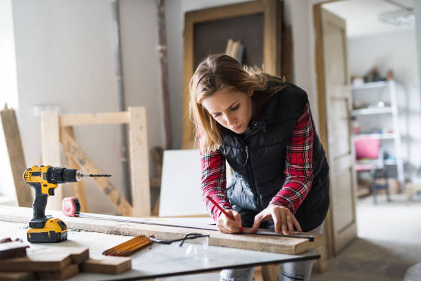 Woman marking wood with a pencil and ruler.